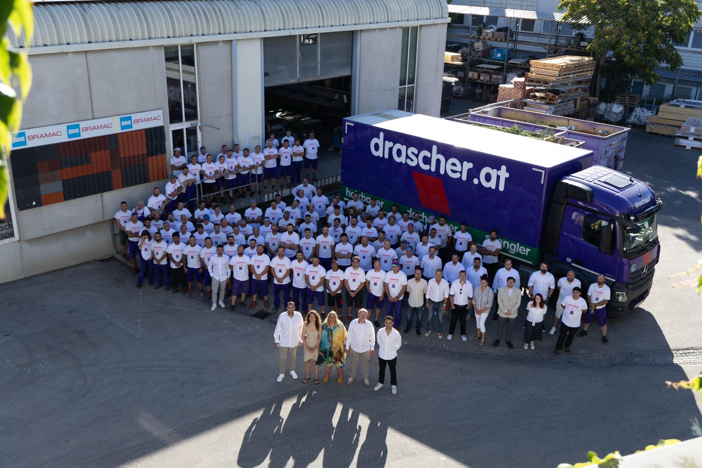 Das gesamte drascher-Team vor dem violetten Firmen-LKW am Betriebsgelände in Wien